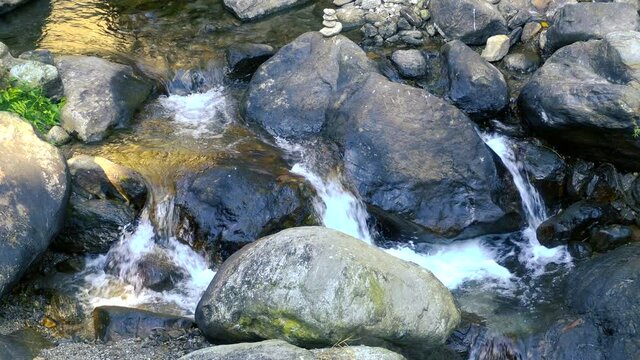 Scenic waterfall passing through rocks. Footage shot at Jhalong, Dooars, West Bengal, India. Dooars if famous for beautiful landscapes.