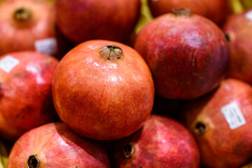 close up ripe red pomegranates sale in fruits market
