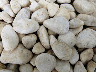 Background of white pebble stones in their natural state of different sizes and shapes. A gravel stone in the yard Pattern and texture.
