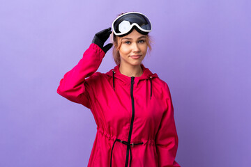 Skier teenager girl with snowboarding glasses over isolated purple background having doubts