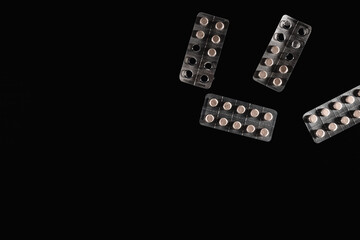 Pills in aluminium packaging isolated on a black background 