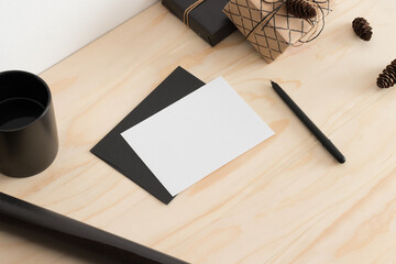 White card mockup with christmas decoration on a wooden table.