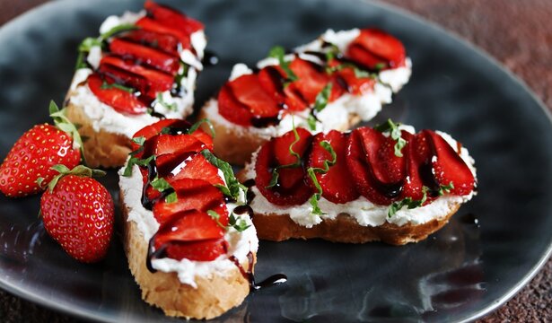 Sandwich with strawberries. With soft cheese and balsamic vinegar. Dark background. Soft focus.