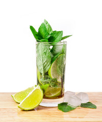 Cocktail mojito with mint leaves, lime and ice on a cutting board isolated on a white background.