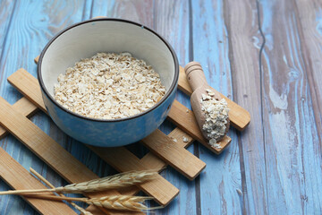 uncooked oats flakes wooden background, close up