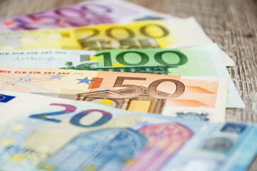 Obraz premium Euro banknotes with different denomination on a wooden background. Close-up. Financial concept.