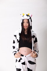 six months pregnant in Cow Mascot Costume on white background.