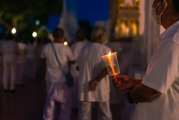  Makha Bucha Day or Vesak Day. Many people holding lit candle and walk around Big Buddha. Visakha Puja Day , Makha Bucha Day, Buddha statue at Thailand.