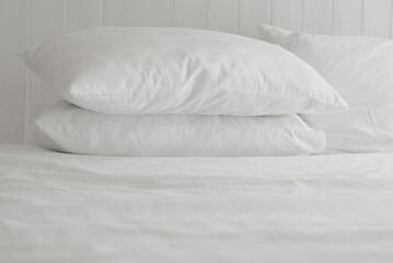 Fototapeta na wymiar Soft and calm atmosphere image of all white bed room. Pillows and blanket on empty bed, close up.