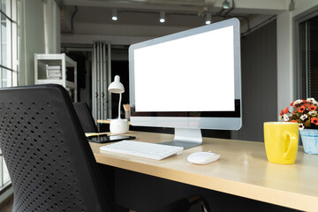 Empty computer monitor screen for design mock up template in modern small office interior or home office. Stylish workplace for creative occupation.