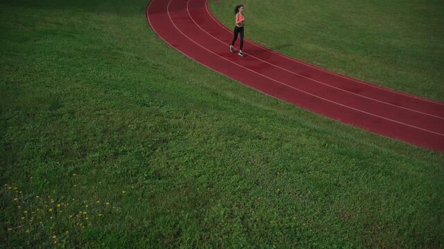 sporty athletic female runner workout outdoor at stadium track
