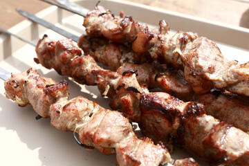 Tray with cooked pork neck on skewers