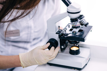 medical technician look at the microscope in medical laboratory