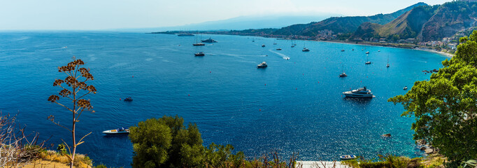 A panorama view of the bay of Naxos from Taormina, Sicily in summer - obrazy, fototapety, plakaty