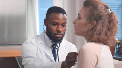 Fototapeta na wymiar Young male doctor visiting woman patient at home