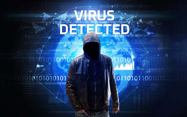 Faceless hacker at work with VIRUS DETECTED inscription, Computer security concept