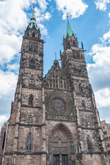 Fototapeta na wymiar Church of St. Lawrence under a blue sky with moving clouds. Nuremberg, Germany, Bavaria.