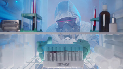Lab technician checking blood samples in fridge for later use