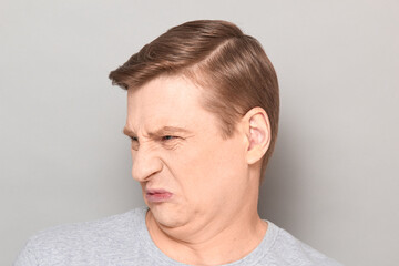 Obraz premium Portrait of funny man grimacing from disgust and squeamishness
