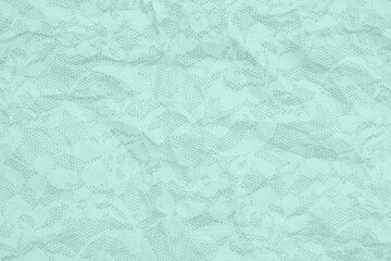 Green wrinkled textured paper background with lace overlay