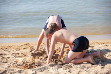 children on a beach being played sand