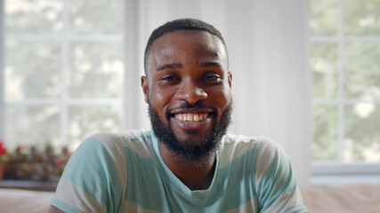 Portrait of happy african american freelancer sitting at workplace in home office,