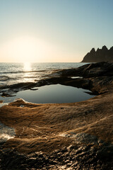 Beautiful sunset, polar day on Senja, northern Norway. Popular place called devil teeth - Tungeneset. Water flowing through rocks into the sea. 