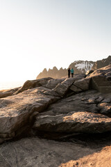 People walking on the Tungeneset (devil teeth) point view, Senja island, northern Norway. Beautiful sunset, white night on the arctic circle. Characteristic sharp mountains.