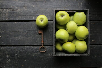 Ripe green apples box on wooden table. Top view with space for your text