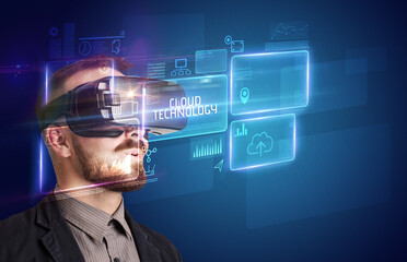 Businessman looking through Virtual Reality glasses with CLOUD TECHNOLOGY inscription, new technology concept