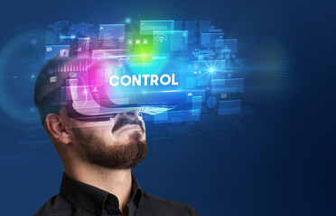 Businessman looking through Virtual Reality glasses with CONTROL inscription, innovative security concept