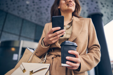 Pleased woman with a cellphone gazing into the distance