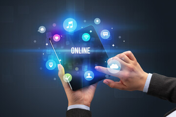 Businessman holding a foldable smartphone with ONLINE inscription, social media concept