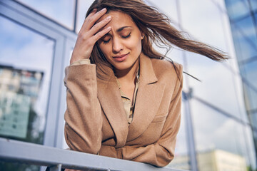 Modern stylish female entrepreneur suffering from a headache