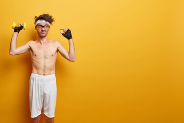 Photo of unimpressed European man shows small gesture, tells how much he worked on muscles, lifts...
