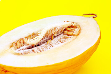 Yallow melon cut in half on yellow background. Summer fuit and healthy eating concept.