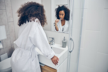 Woman brushing her teeth with her eyes closed