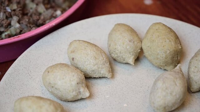 Woman hands making and preparing middle eastern traditional food. Delicious Kibbeh, famous in Arabic country especially in  Lebanon, Syria.