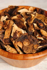 Dried mushrooms in wooden bowl. Boletus badius.