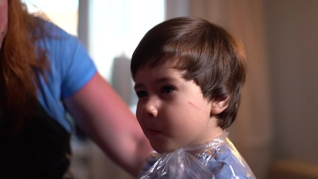 Little boy using scissors at home, portrait plan. 4K. Live camera