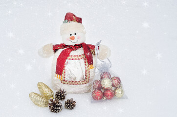 Christmas and New Year background greeting card with copy space. Snowman under the falling snow with Christmas balls.