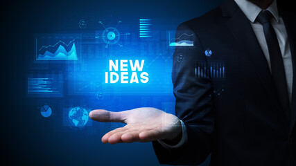 Hand of Businessman holding NEW IDEAS inscription, business success concept