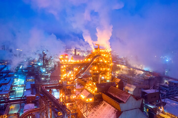 Night top view of steel plant at night with smokestacks and fire blazing out of the pipe....
