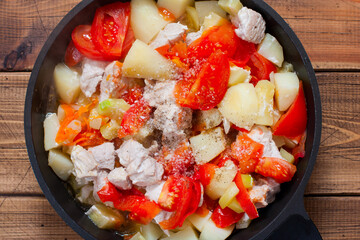 Step by step preparation of vegetable stew with turkey, step 7 - adding salt and spices to the cooked vegetable stew, top view, selective focus