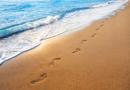 footprints on  tropical beach and beautiful  wave