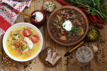 pea soup and vegetable soup with beans and sour cream on a wooden table
