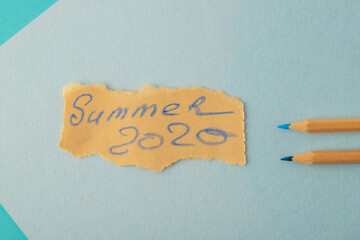 wooden pencils and note on crafted paper on blue background close up