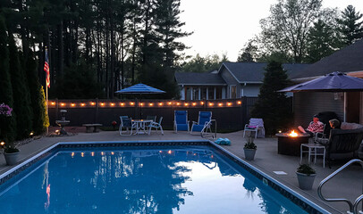 backyard pool with firepit at dusk