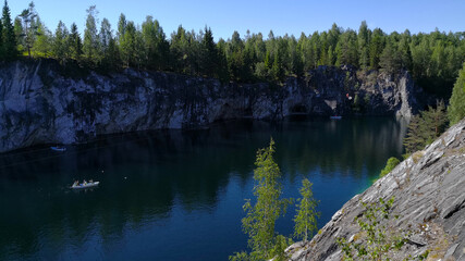 Tourist complex Karelia. Sunny summer day in the Marble Canyon. View of the flooded quarry with turquoise water.