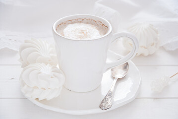 Coffee and marshmallow on a white wooden background